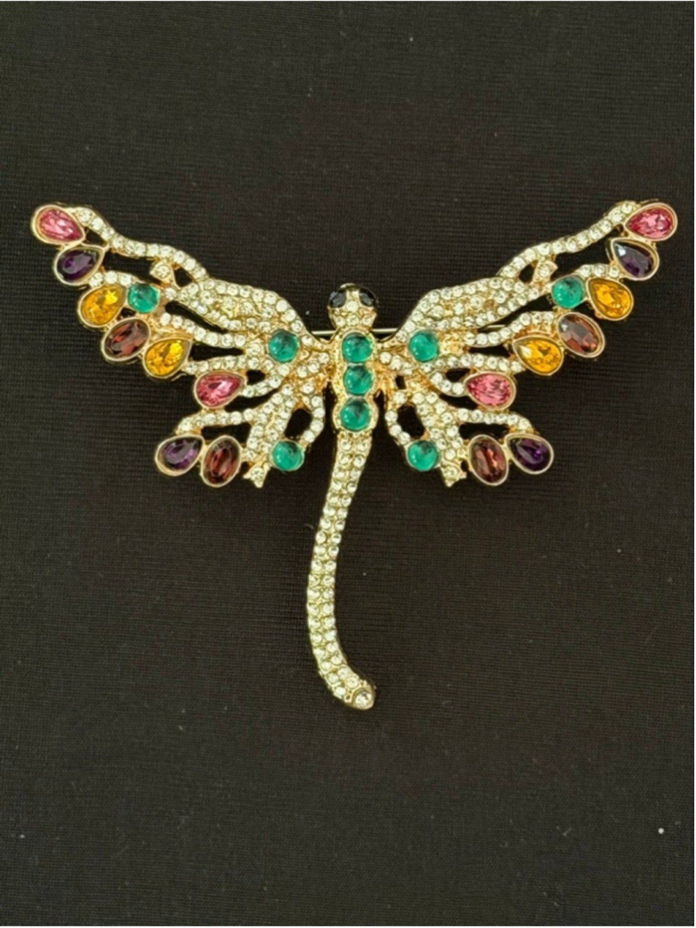 gold-tone dragonfly brooch features vibrant, multicolored crystal rhinestones.